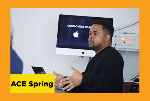 a student explains concepts of graphic design in front of an apple computer. 