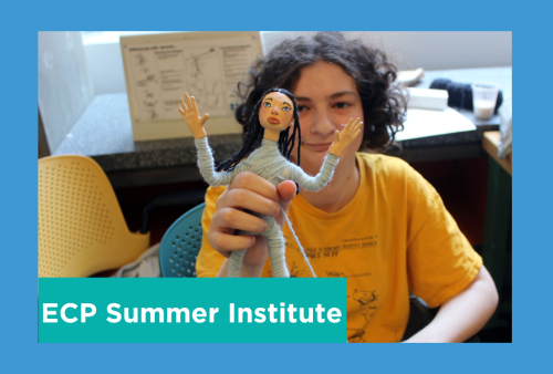 a student holds up an interesting looking poppet that looks like it has escaped an asylum