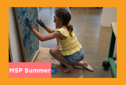 a young student gets down and dirty as she draws with her hands at the art institute