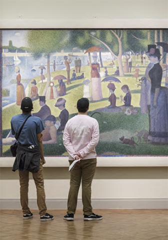 Individuals looking at La Grande Jatte painting