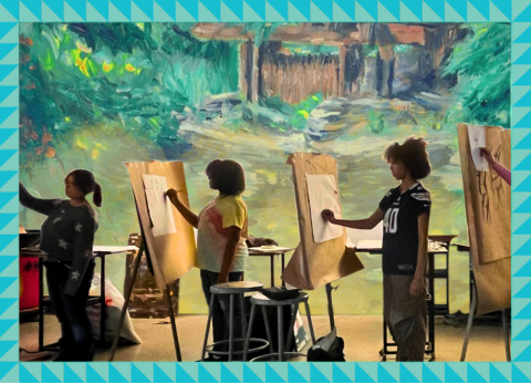three students draw at easels with a painting of a green summer nature scene behind them