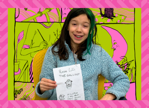 A young girl with a teal streak in her hair holds up her comic. Molly Colleen Occonnell's work is behind her