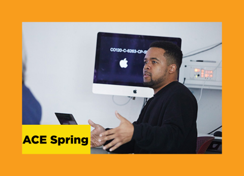 a student explains concepts of graphic design in front of an apple computer.