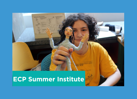 a student holds up an interesting looking poppet that looks like it has escaped an asylum