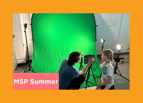 a teacher shows a young student how to light a green screen for color keying in post production