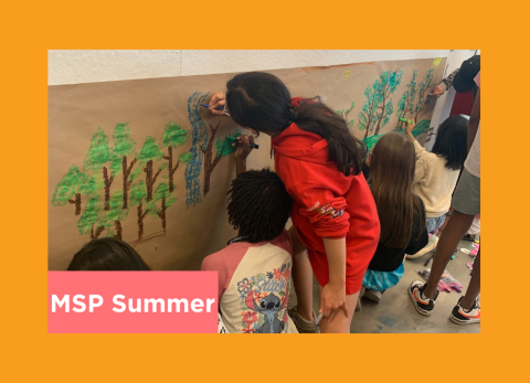 students work on a group project on butcher paper 