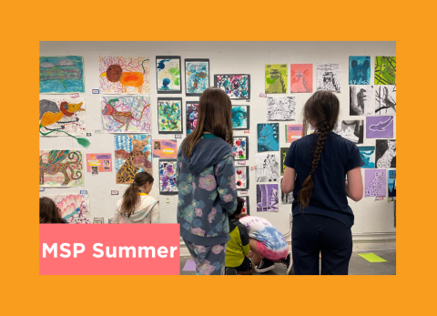 students admire a salon style hanging of their work 