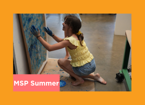 a young student gets down and dirty as she draws with her hands at the art institute
